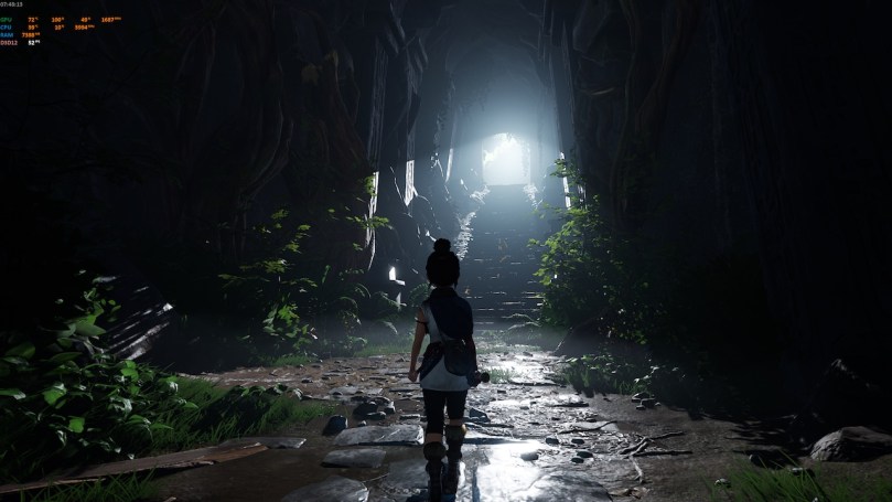 Kena on her way to exit a cave. In front of her are the stairs that lead up to the exit through which light shines down.